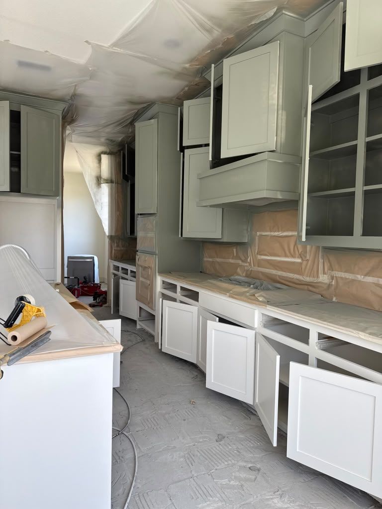 Damaged kitchen with missing cabinet doors, exposed cabinets, and debris on the floor