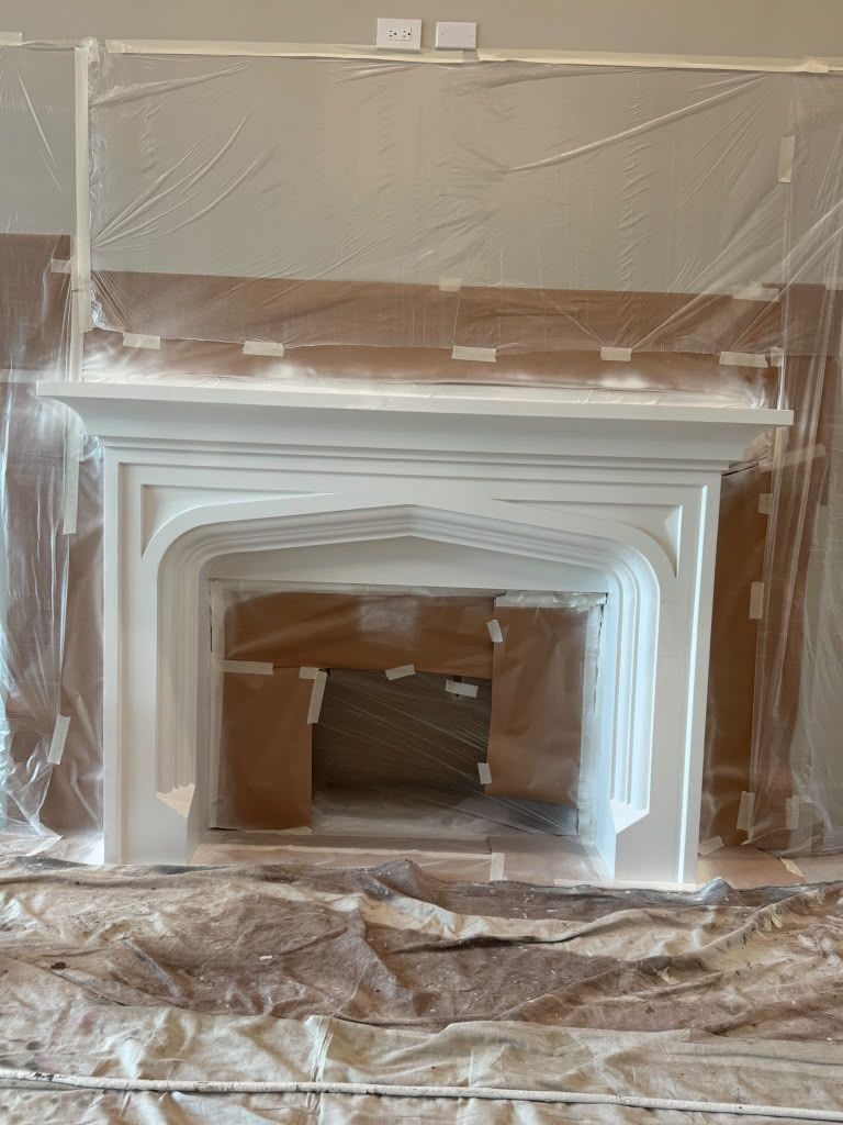 Fireplace mantel and surround covered in plastic sheeting during renovation