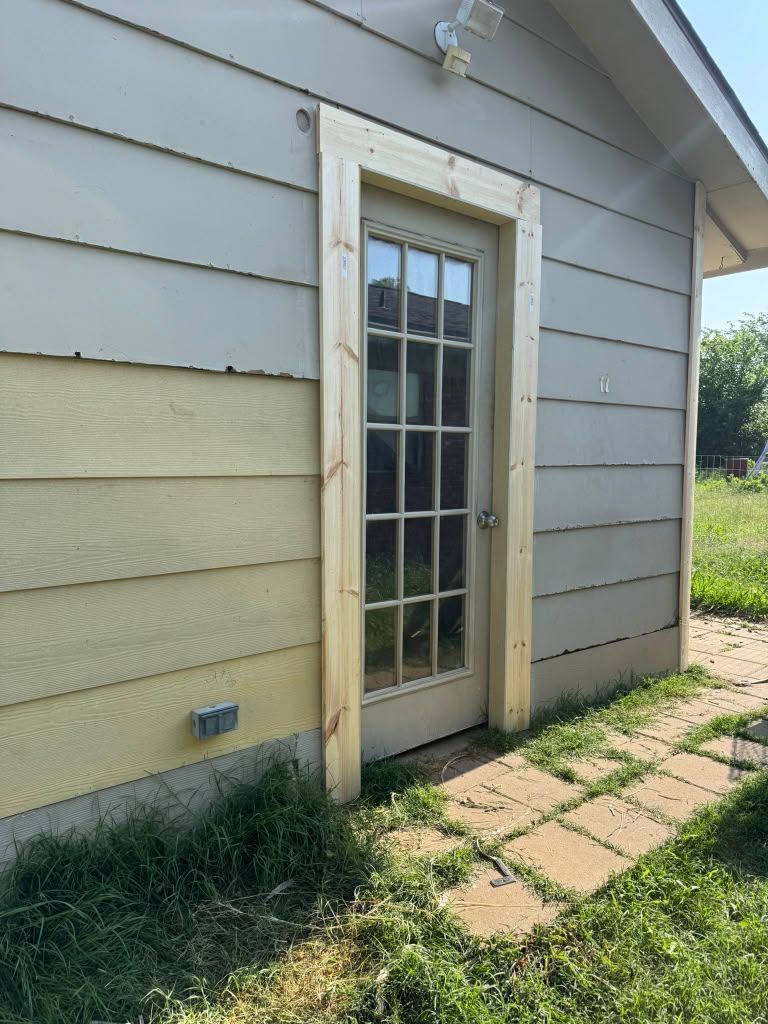 Glass back door on a beige house exterior with a small paved path and grass.