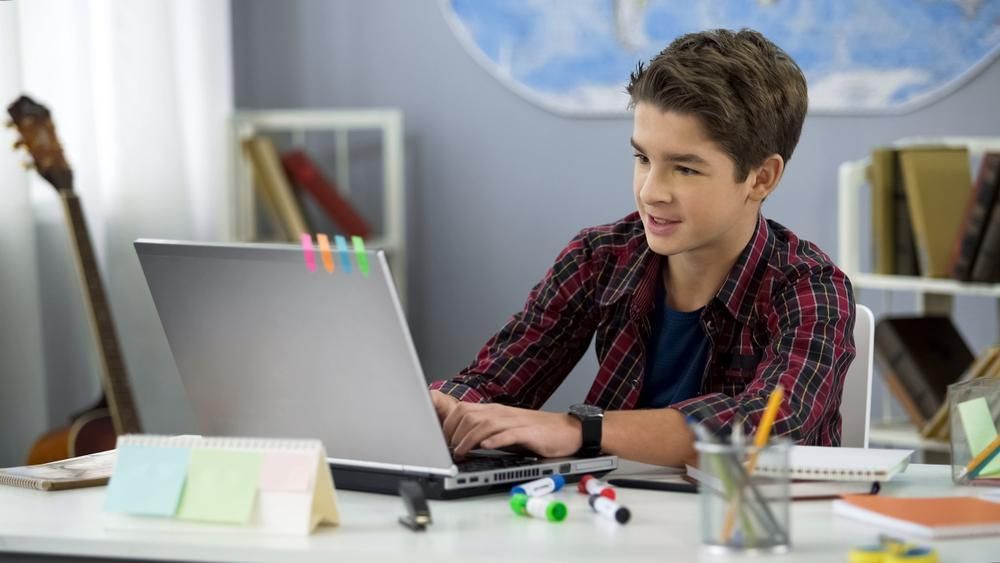 A Young Boy Is Sitting at A Desk Using a Laptop Computer — Al Roberts Education Centre in Wynnum West, QLD
