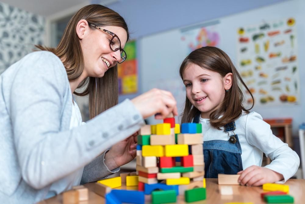A Woman and A Little Girl Are Playing with Wooden Blocks — Al Roberts Education Centre in Wynnum West, QLD