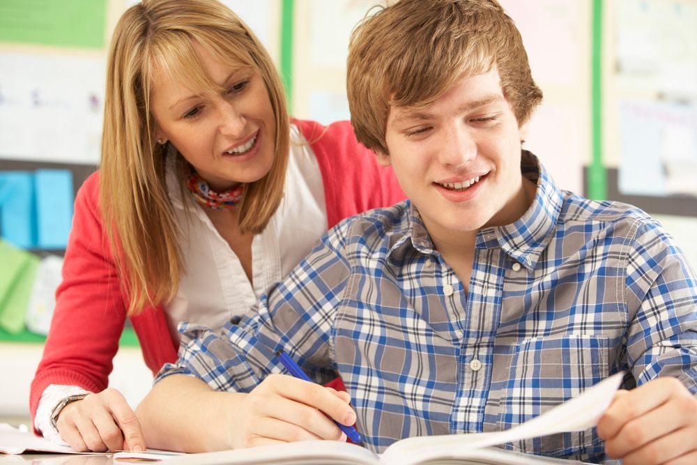 A woman is helping a boy with his homework — Al Roberts Education Centre in Wynnum West, QLD