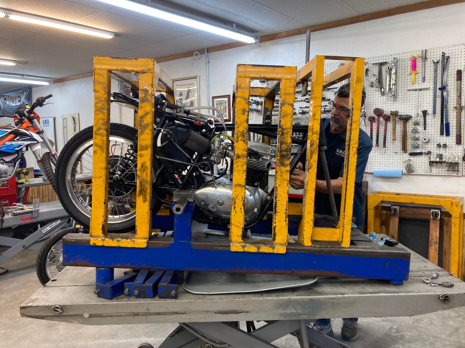 A man is working on a motorcycle in a garage