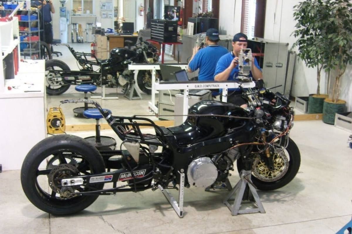 A man is taking a picture of a motorcycle in a garage