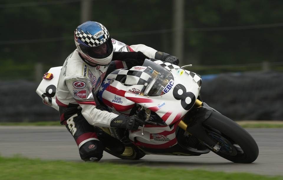 A man is riding a motorcycle with the number 8 on it