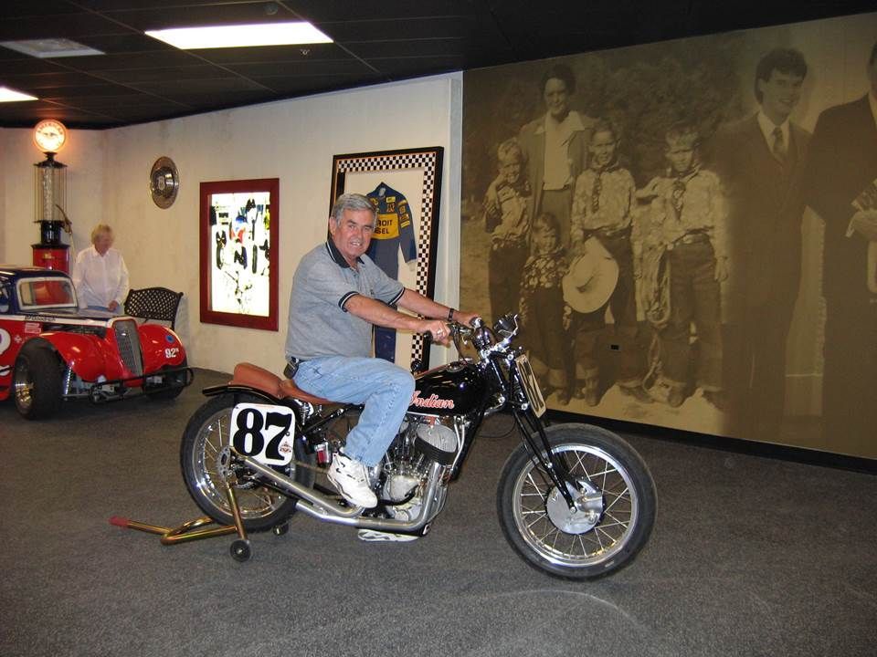 A man is riding a motorcycle with the number 87 on the front