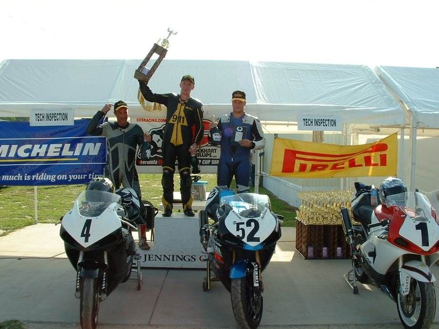 A man holding a trophy in front of a michelin banner