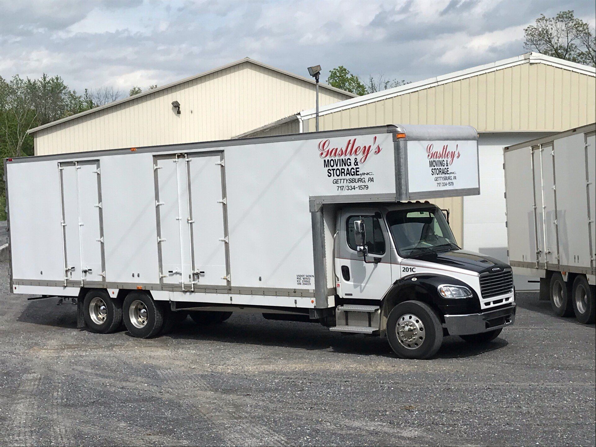 Delivery men unloading boxes — Biglerville, PA — Gastley's Moving And Storage Inc A moving truck outside of storage units near Gettysburg, PA