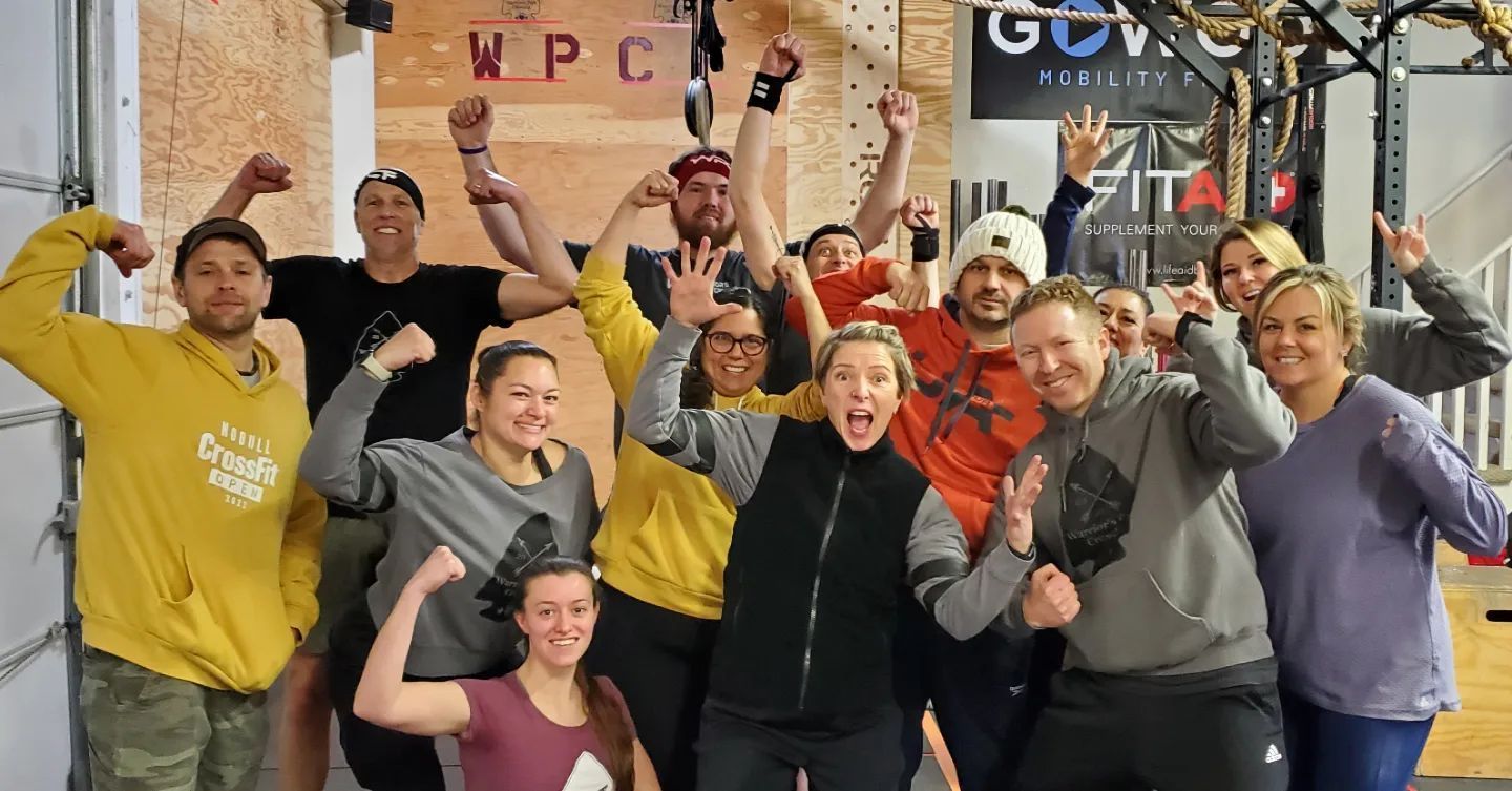 A group of people are posing for a picture in a gym.