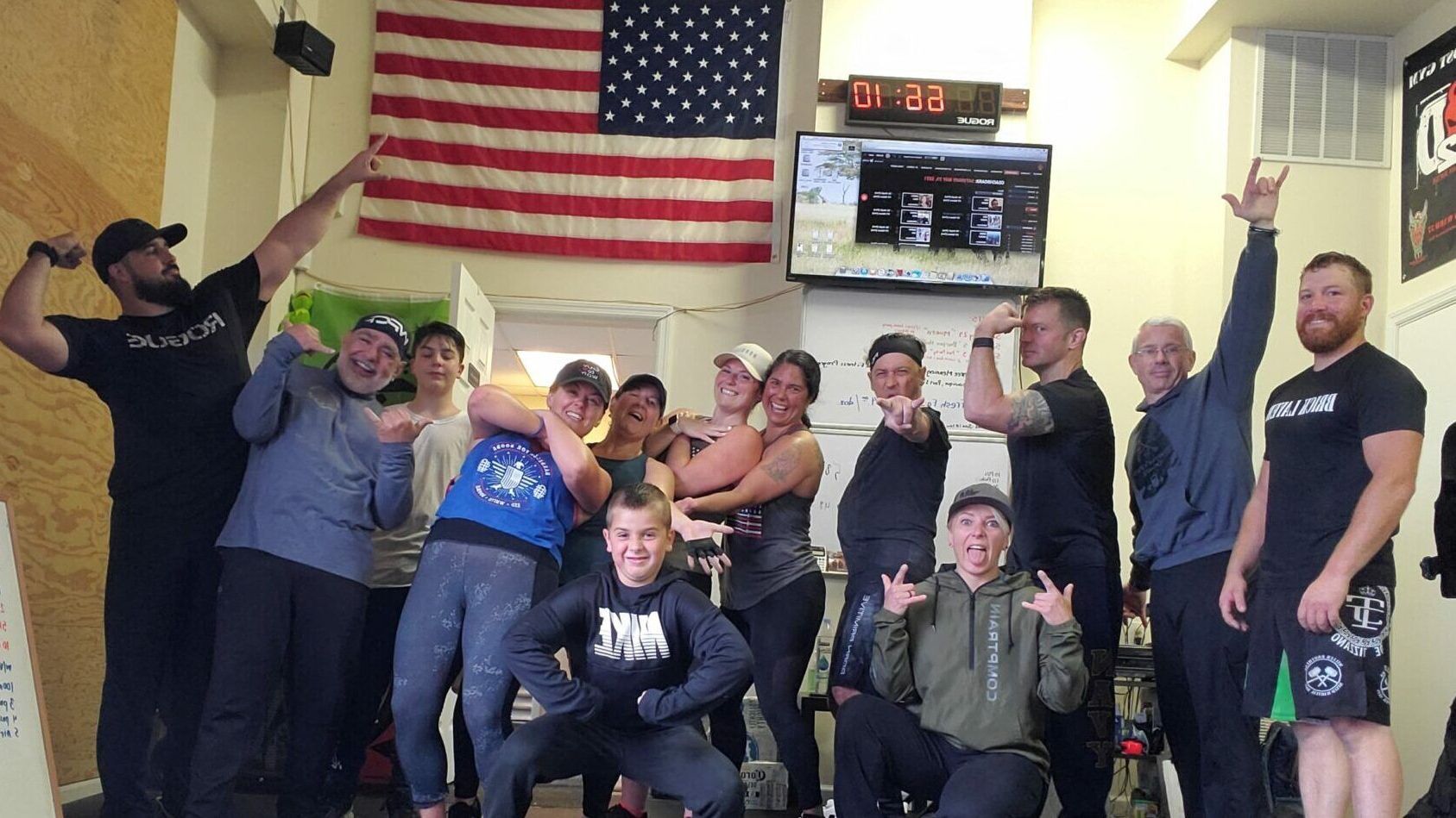 A group of people are posing for a picture in front of an american flag.