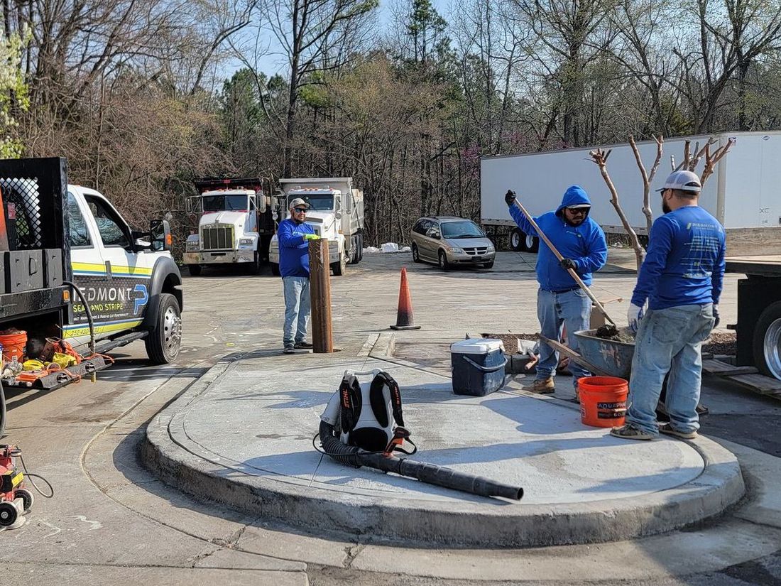 A man in a blue hoodie is smiling in a parking lot
