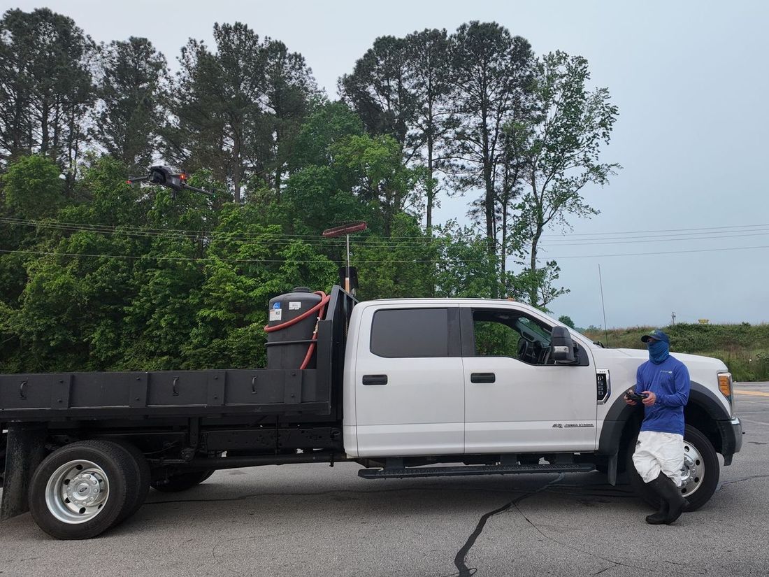 A man in a blue mask is standing next to a white truck.
