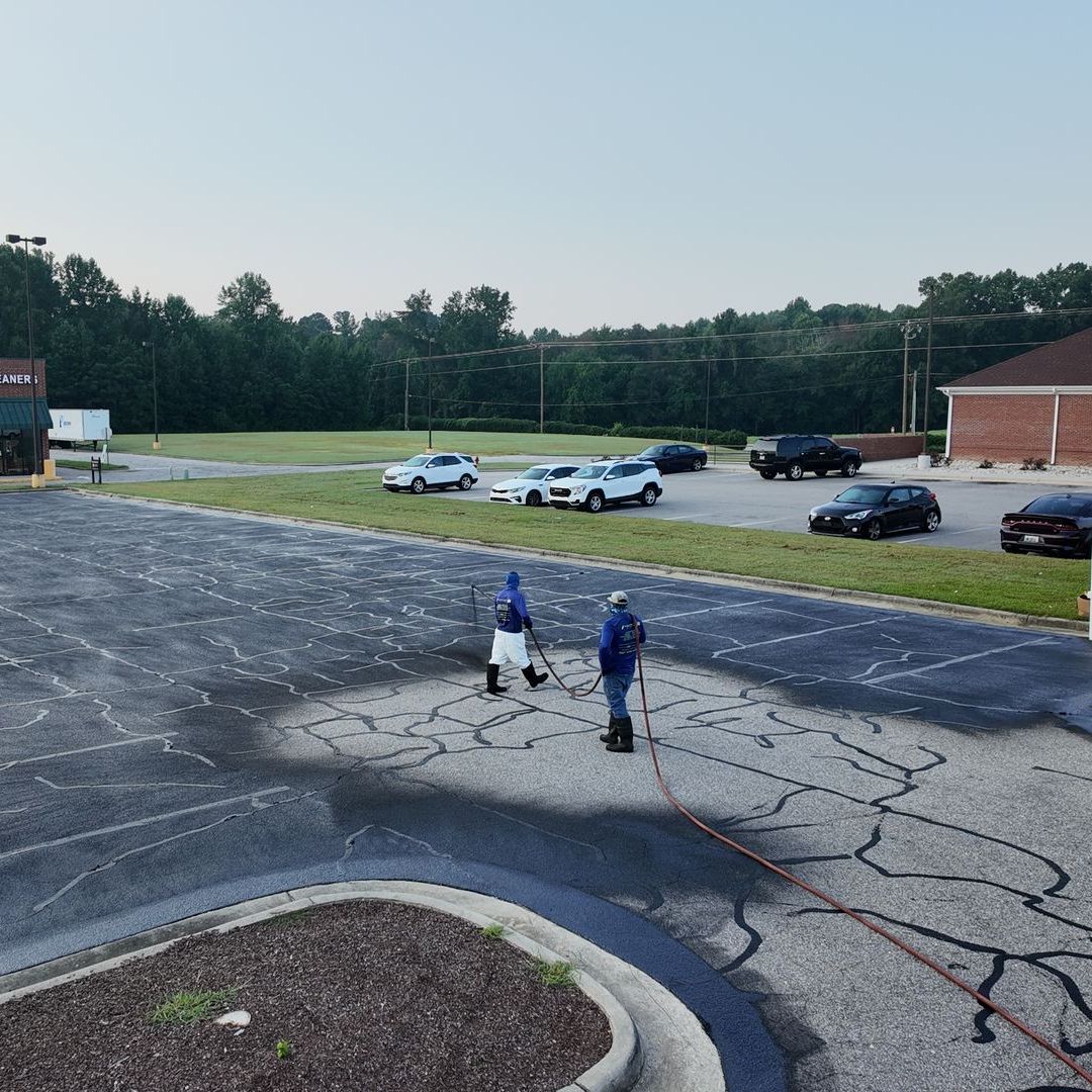 A truck is connected to a propane tank in a parking lot.