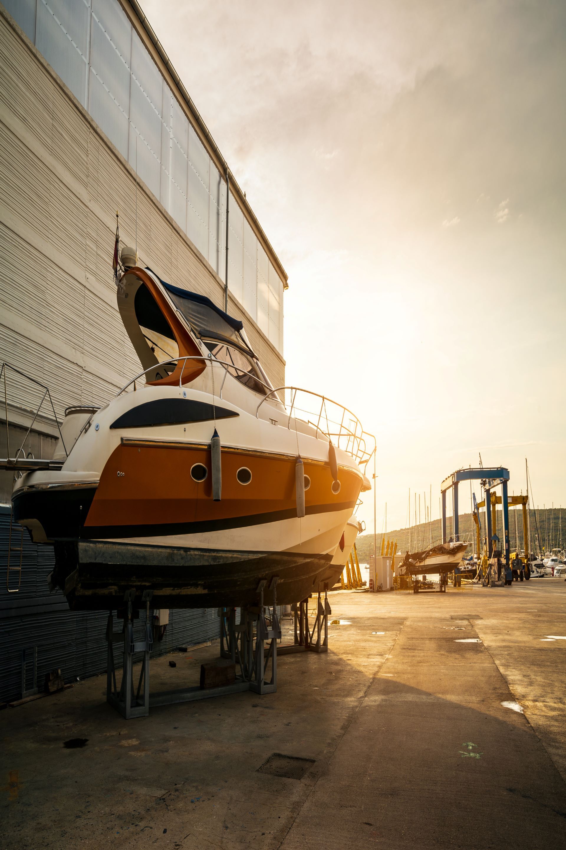 A boat is parked in front of a building in a marina.