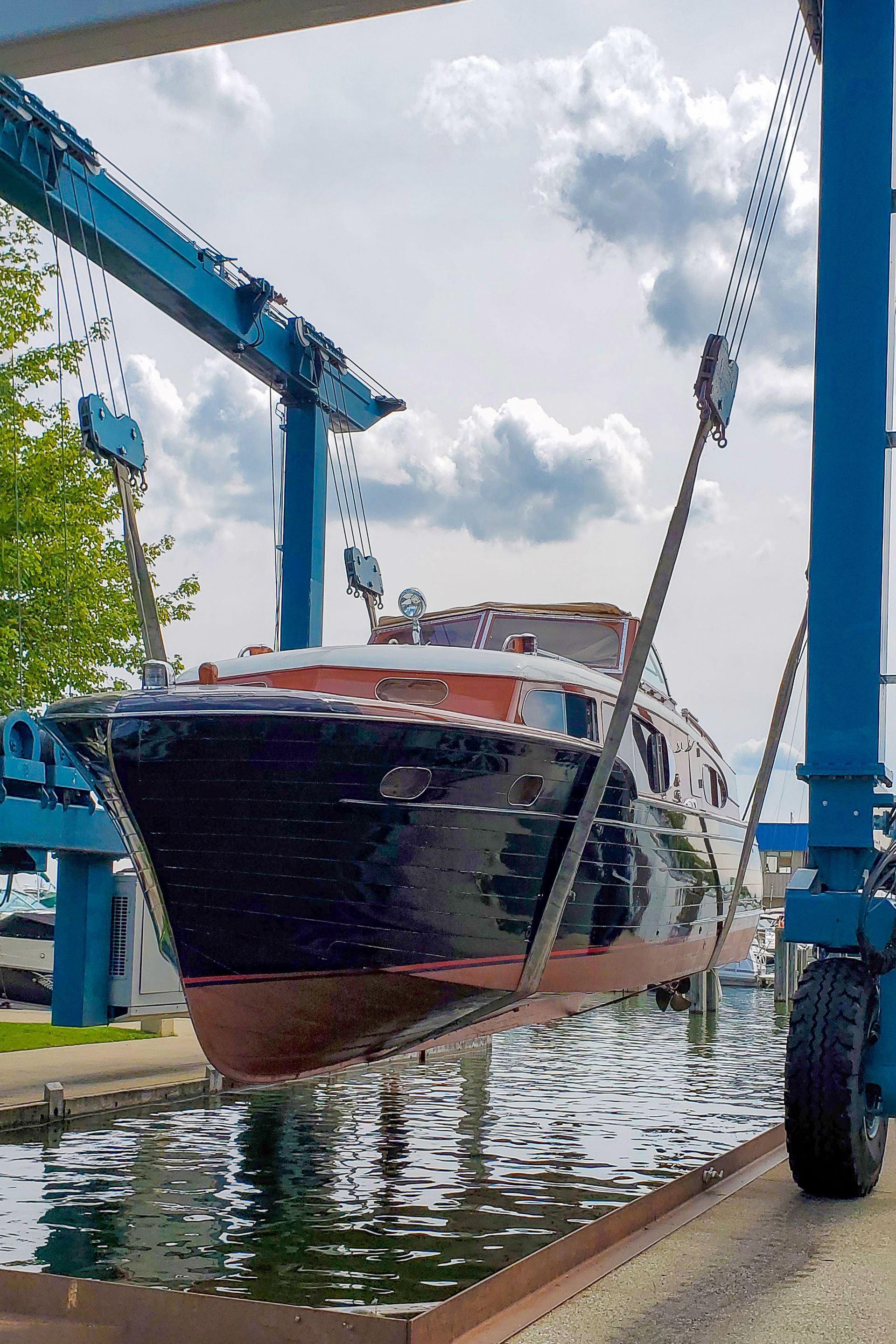 A boat is being held out of the water by a boat lift.