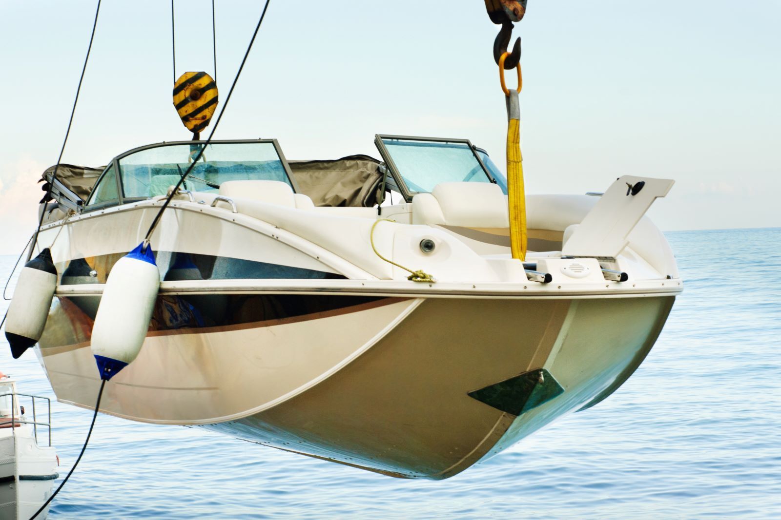 A boat is being held out of the water by a boat lift.