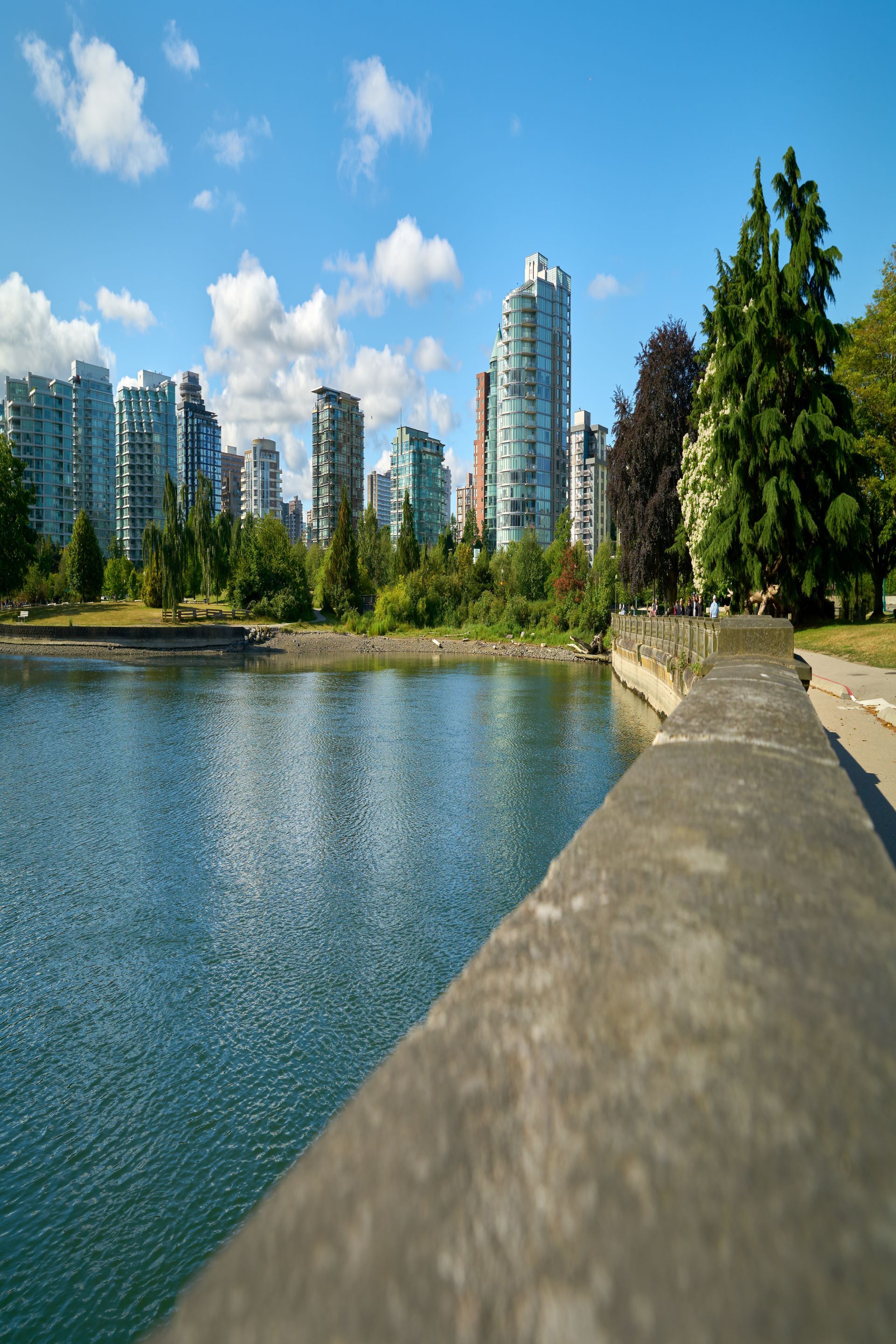 A seawall retaining a body of water with a city skyline in the background