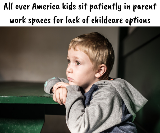 A young boy sits at a table with his head resting on his hands