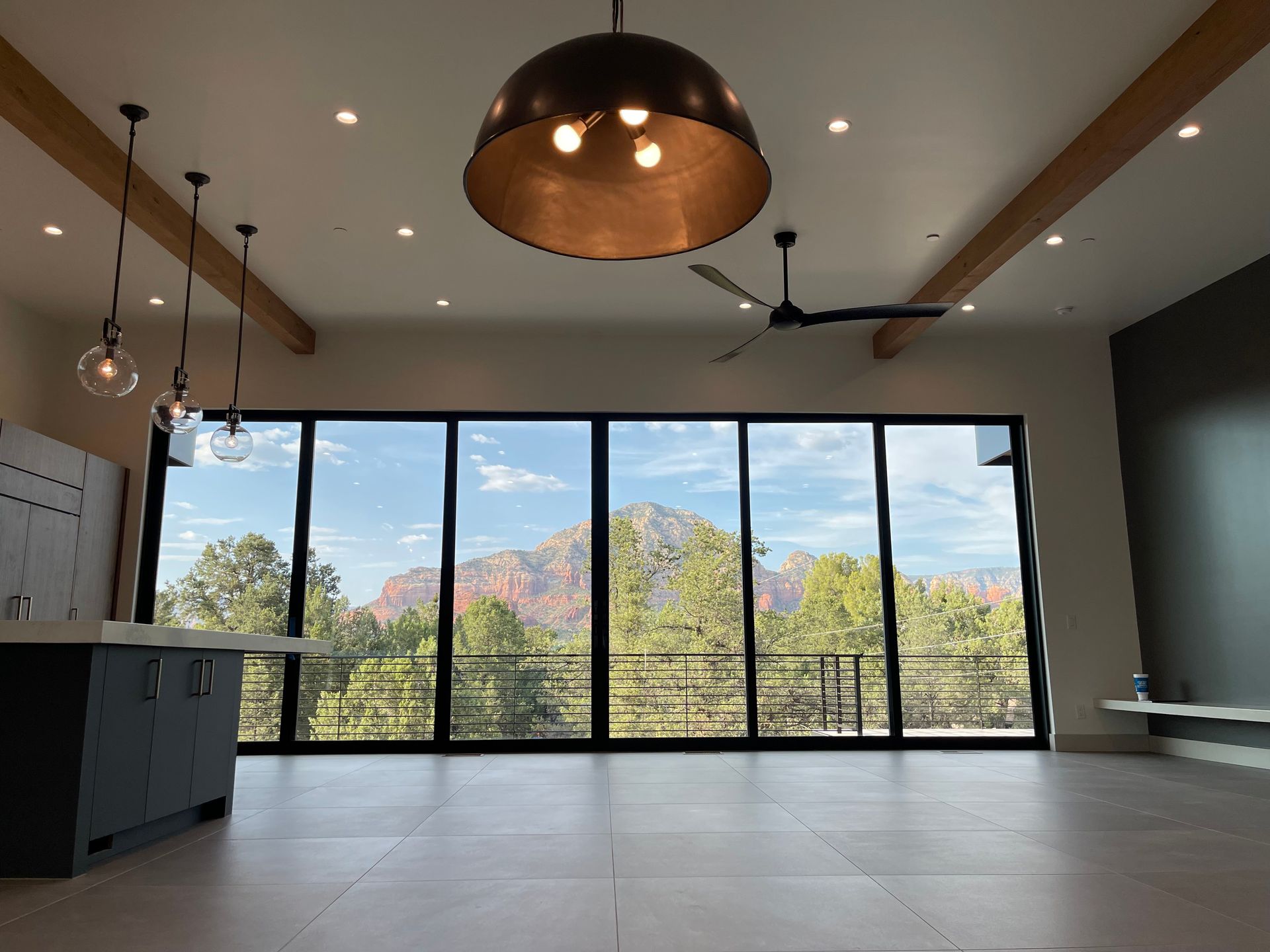 A large room with a lot of windows and a ceiling fan