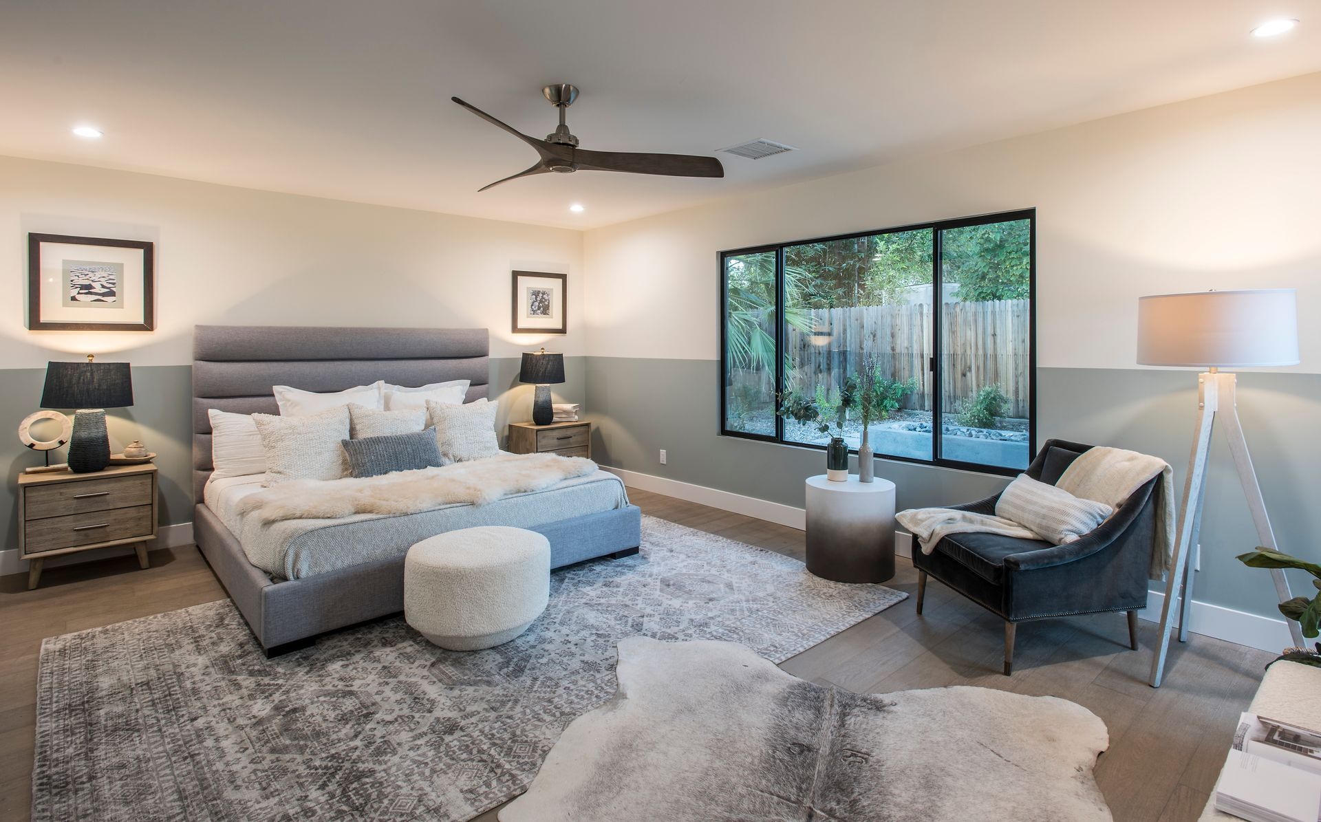A bedroom with a large bed and a ceiling fan