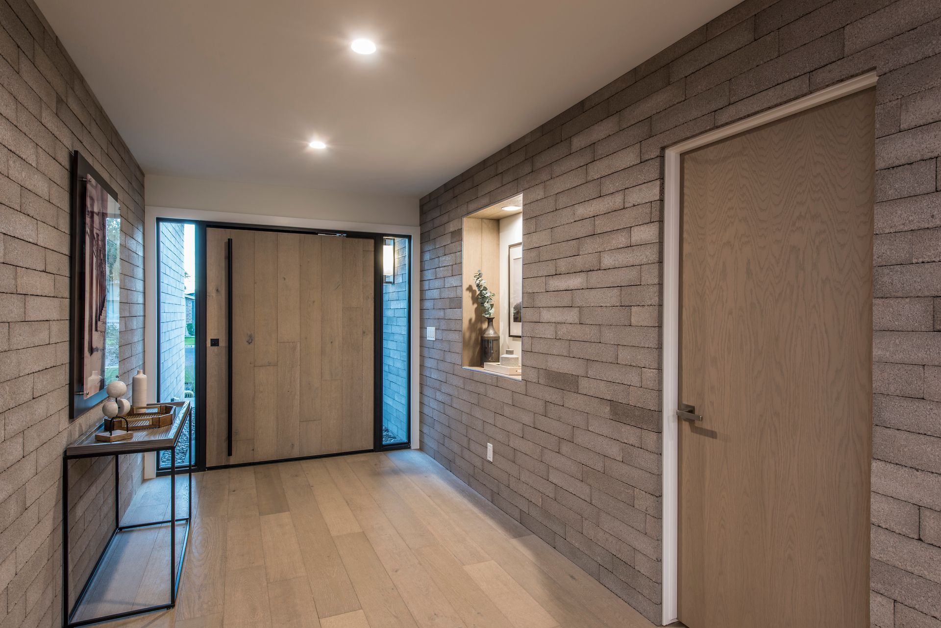 A hallway with brick walls and wooden floors in a house.