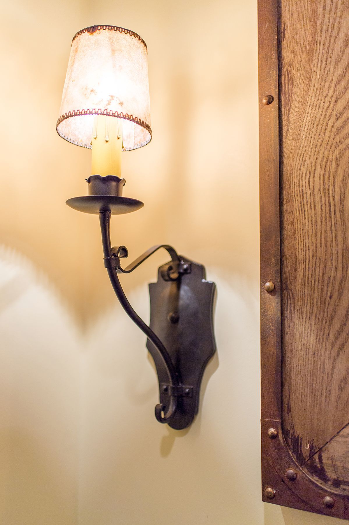 A lamp with a candle on it is hanging on a wall.