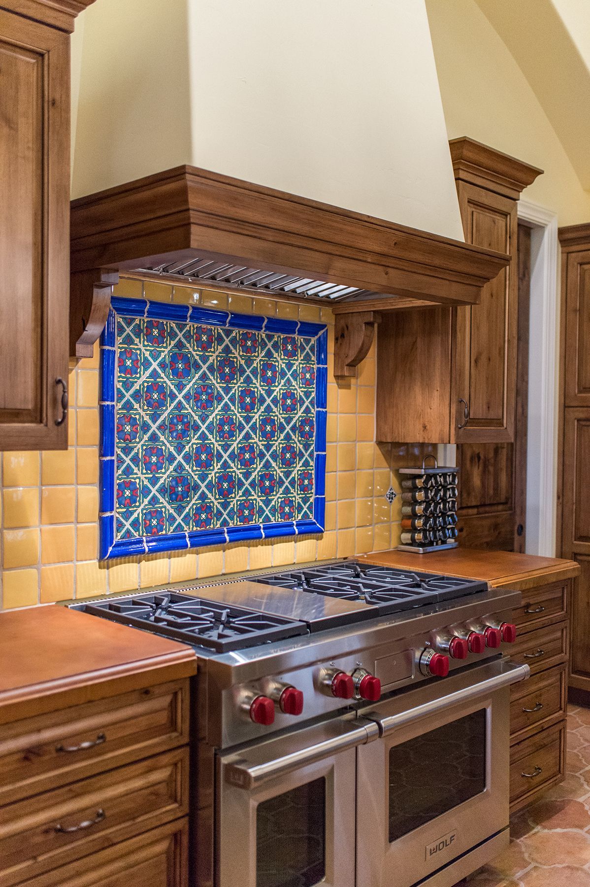 A kitchen with a stove top oven and a hood.