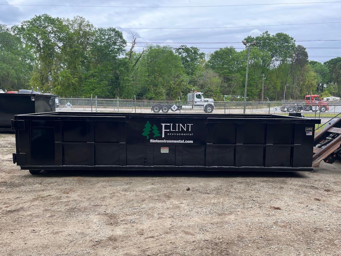 Black dumpster with the words