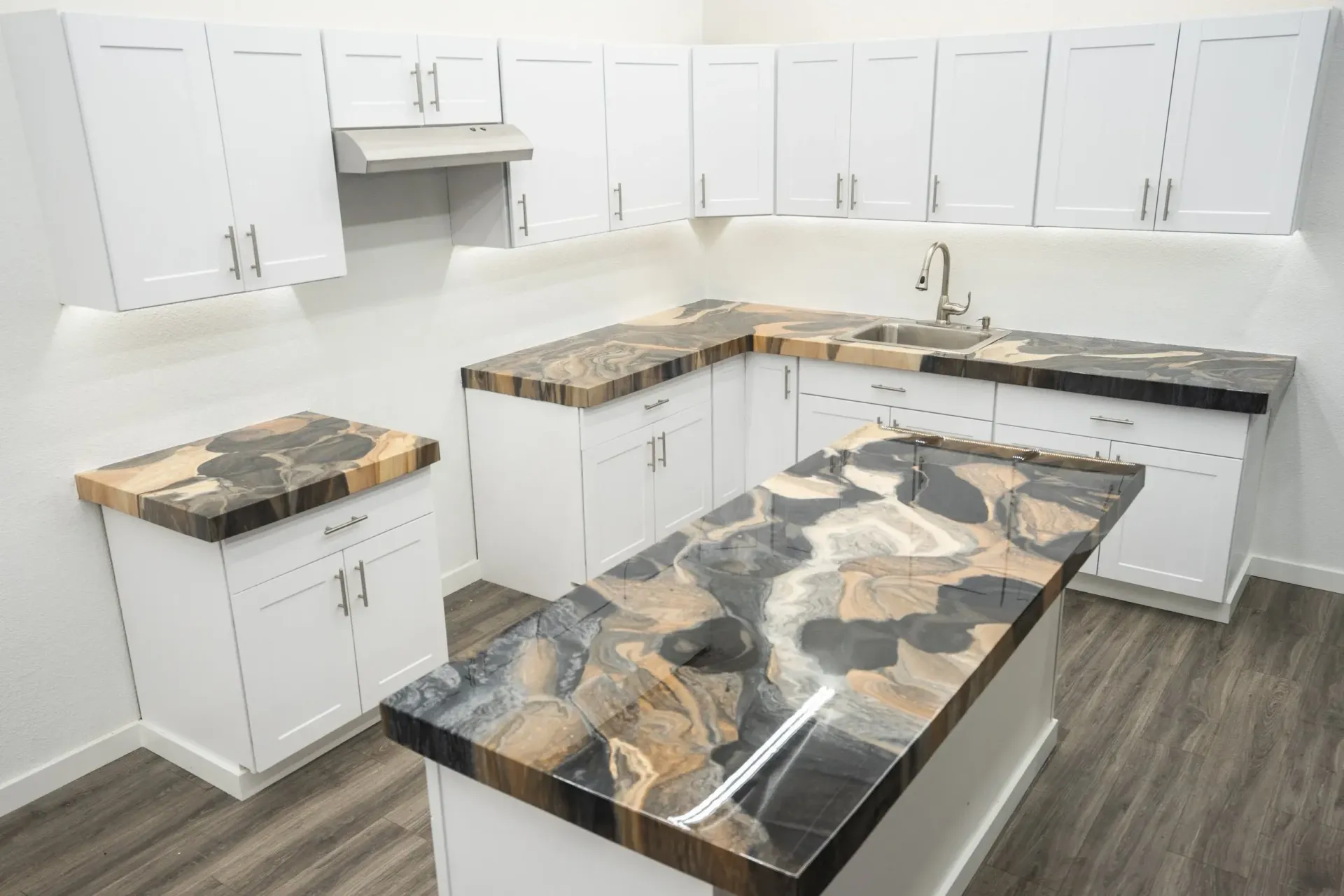 White kitchen with black and gold granite countertops, cabinets, and an island.