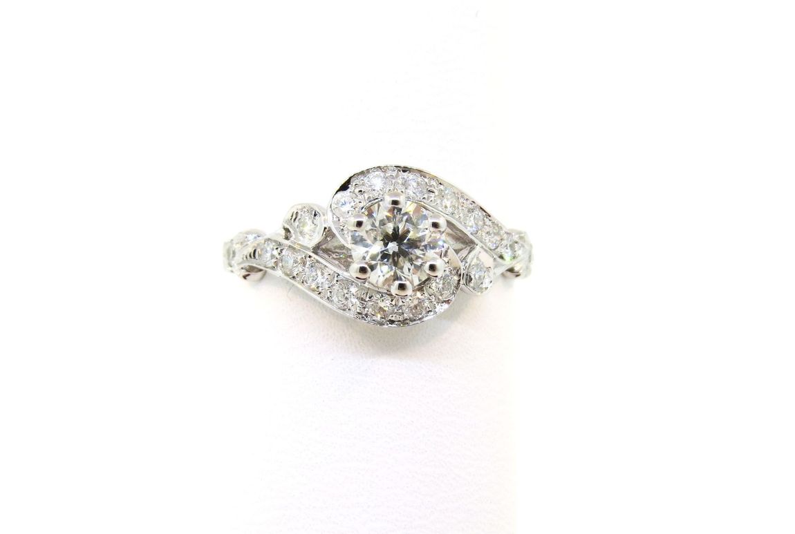 Silver diamond ring with a central round stone and floral cluster details on a white background