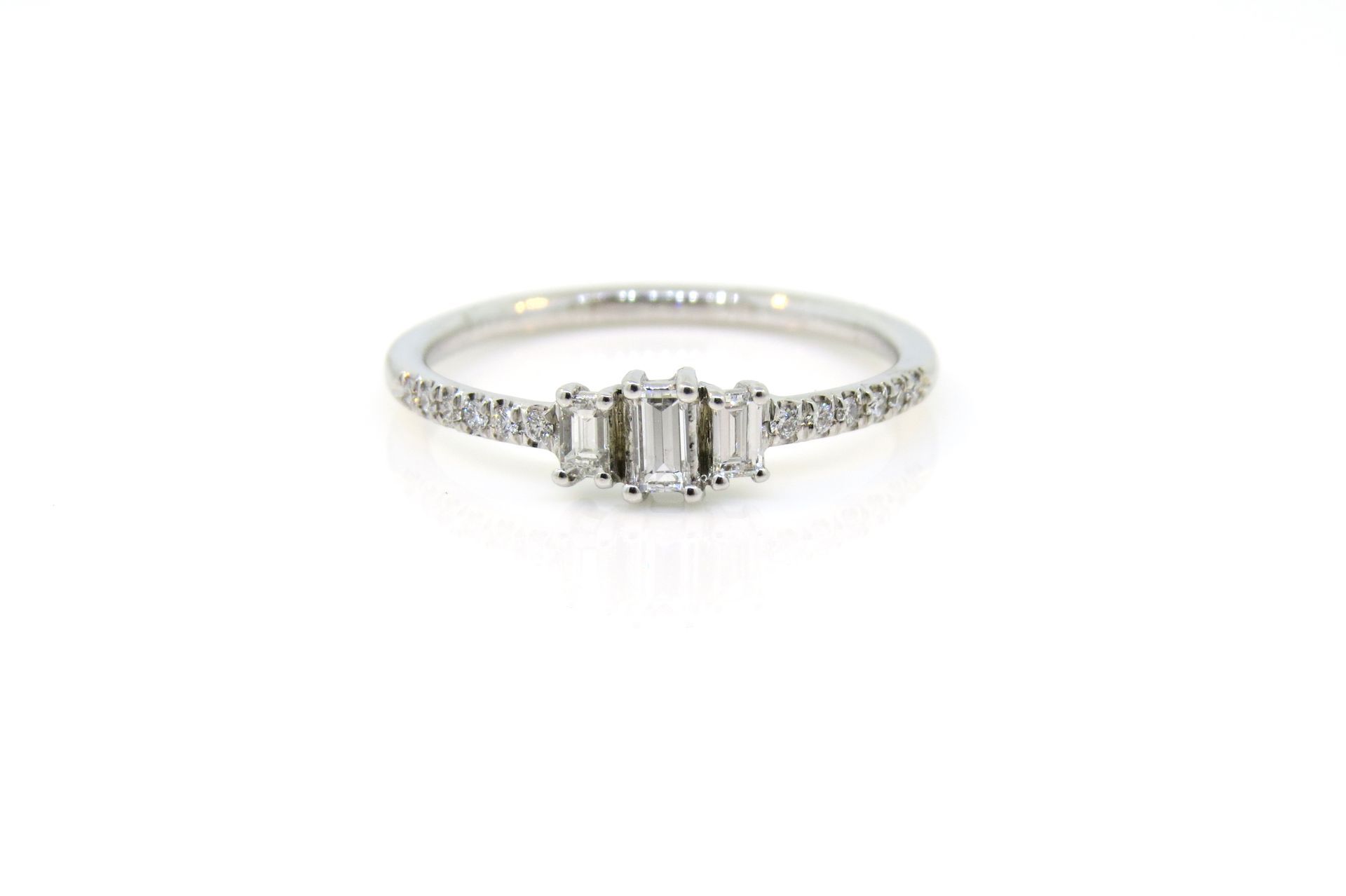 Silver diamond engagement ring with a rectangular center stone on a white background