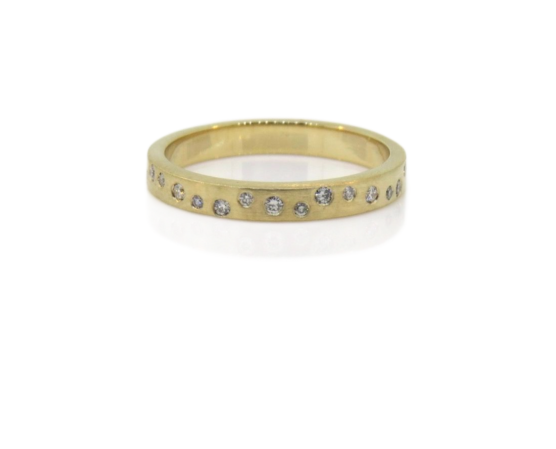 Gold ring with small diamonds on a white display stand