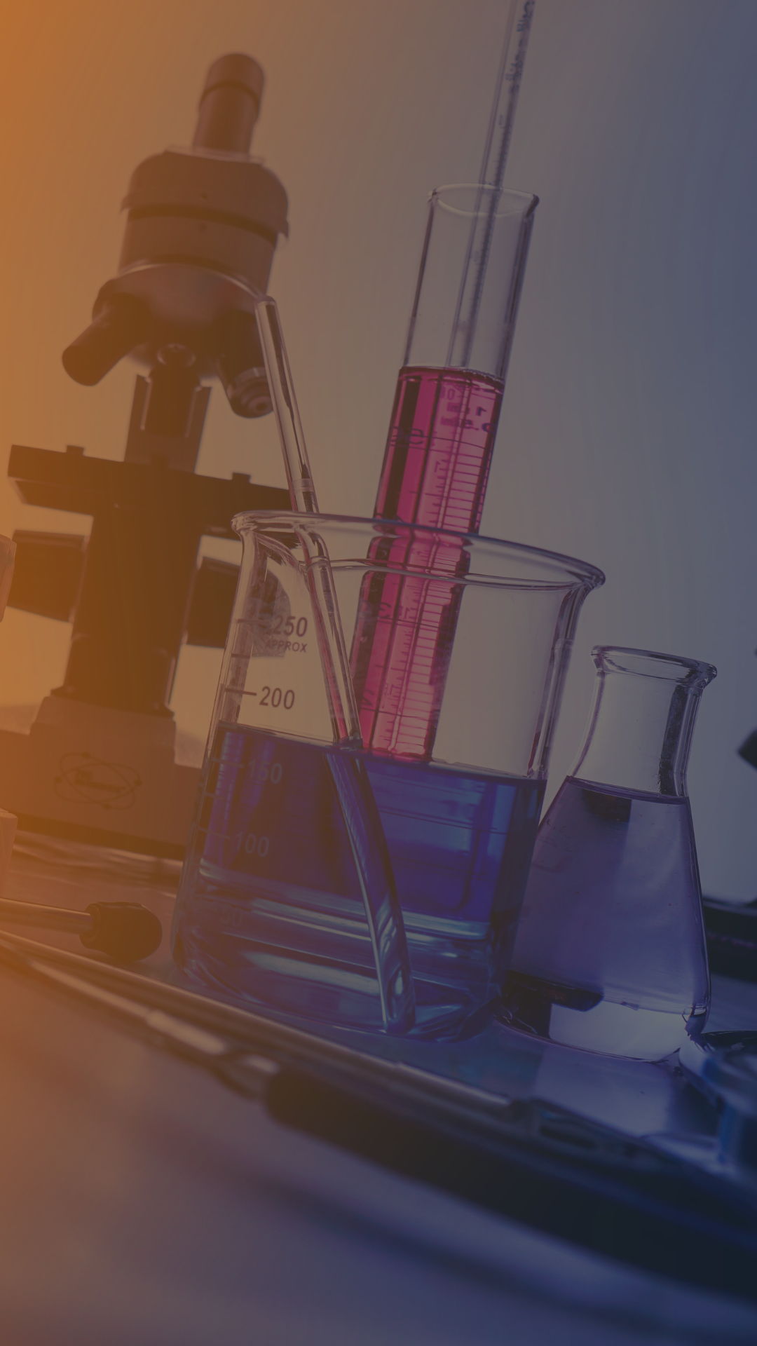A close up of a microscope , beaker , pipette and other chemicals in a laboratory.