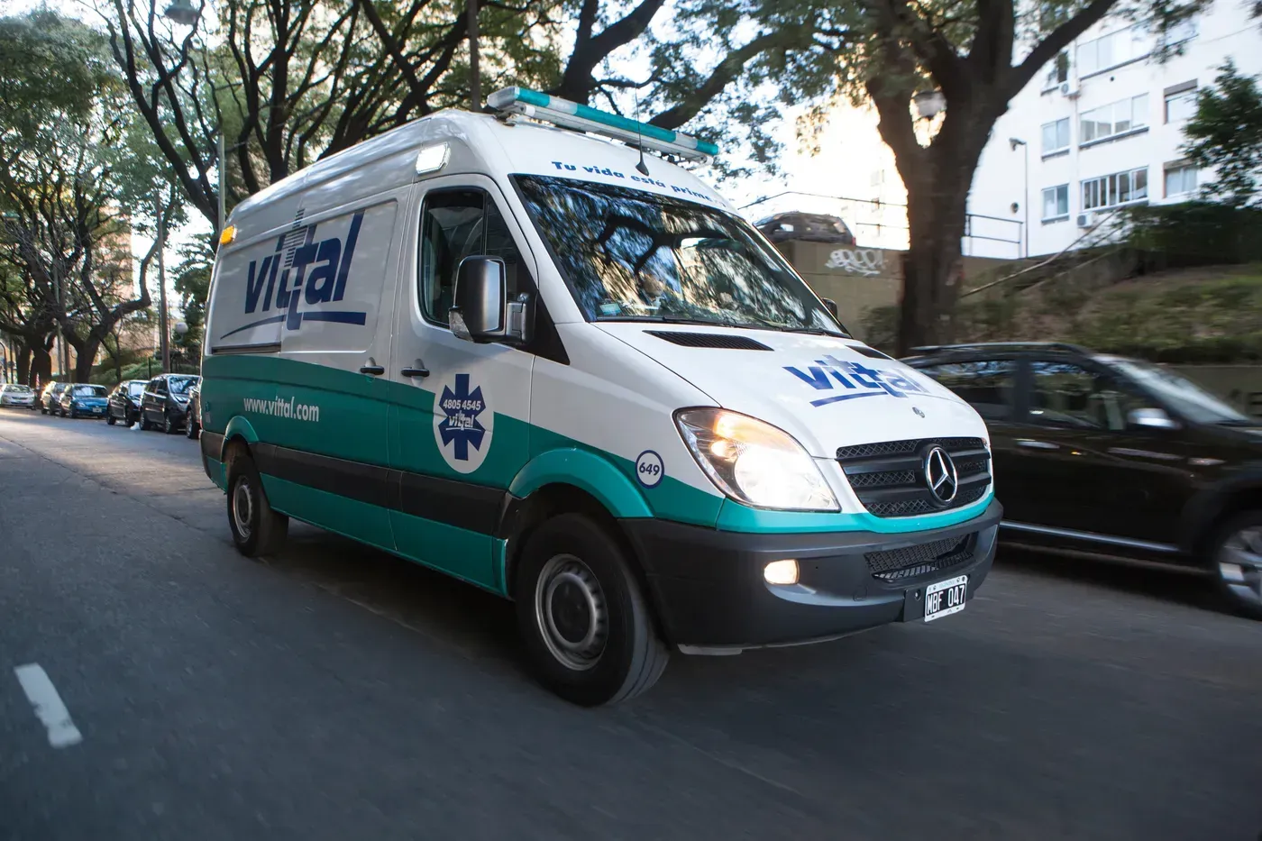 Ambulancia verde de Unimed estacionada en una calle de la ciudad frente a un edificio.