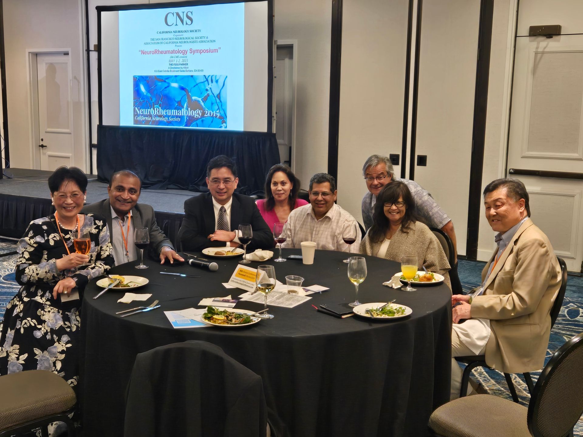 Attendees smiling around a table