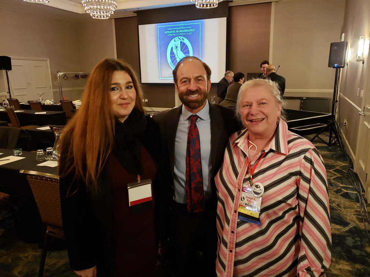 2 board members take a photo with a speaker