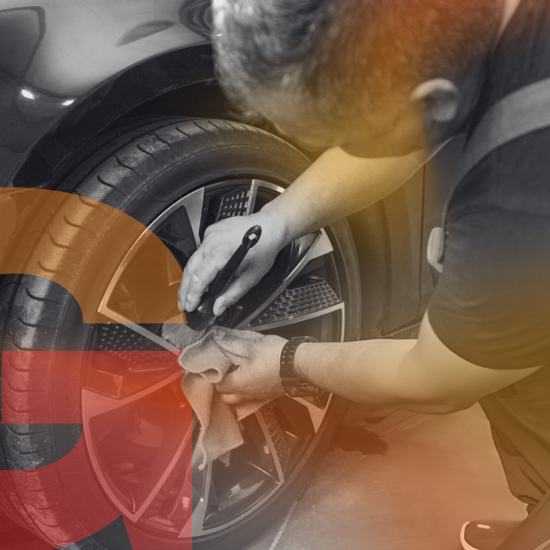 A man cleaning a tire with orange background