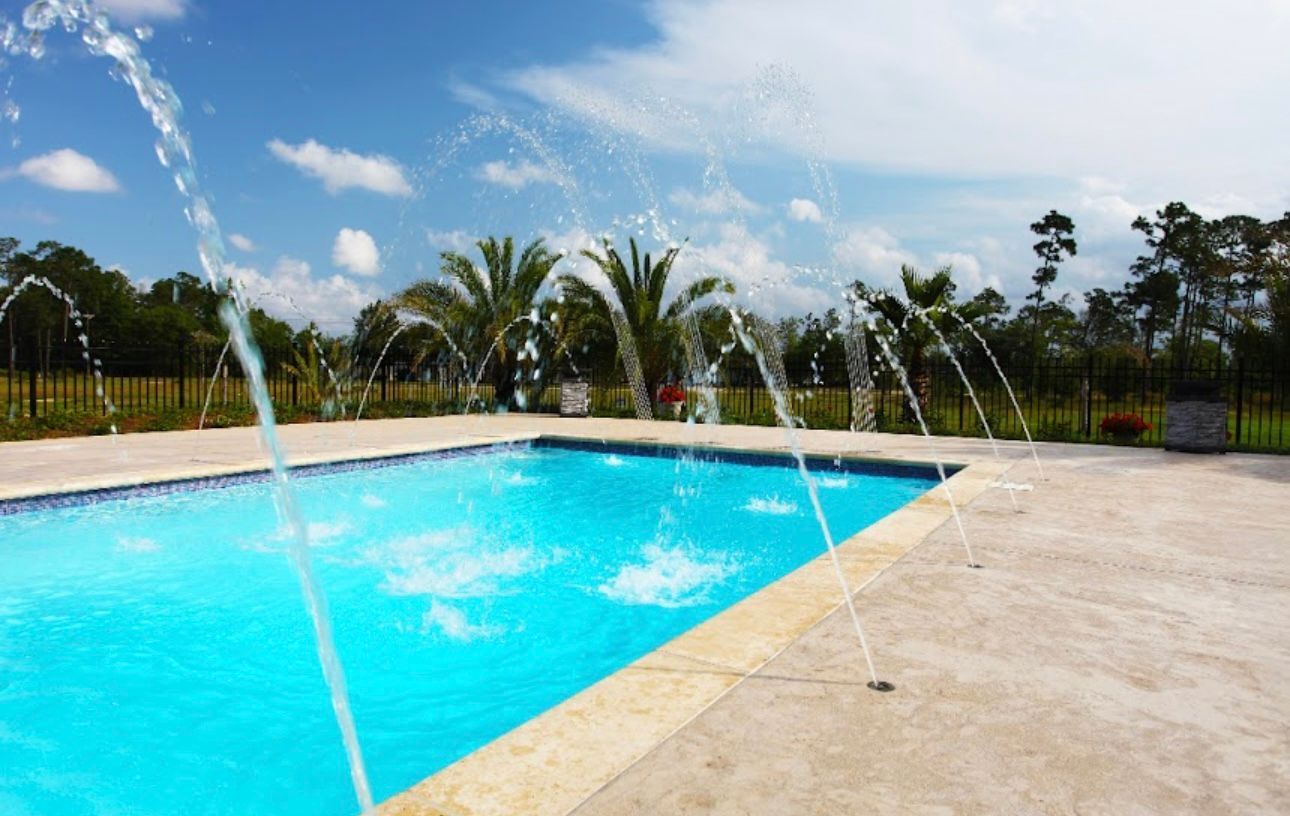A swimming pool with a fountain in the middle of it