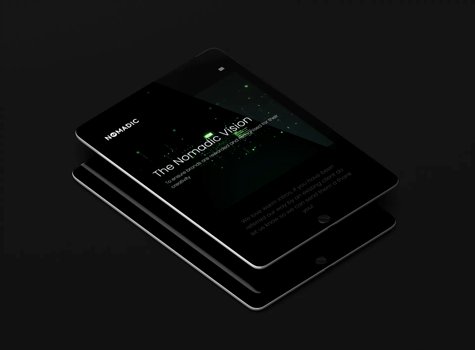 Two black tablets are stacked on top of each other displaying the nomadic Website on the screens