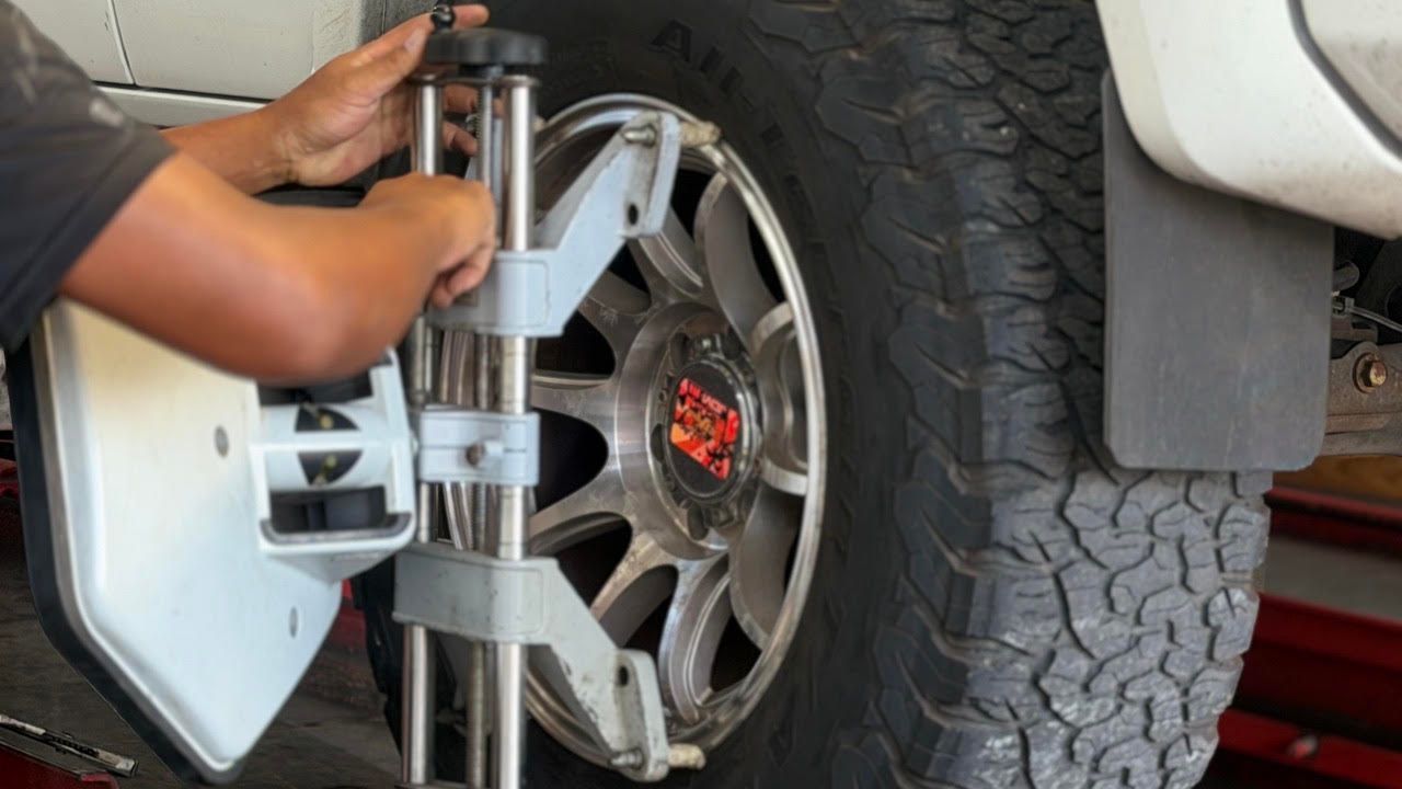 Mechanic using a tire-changing machine on a car wheel in a garage | Sky Auto Repair