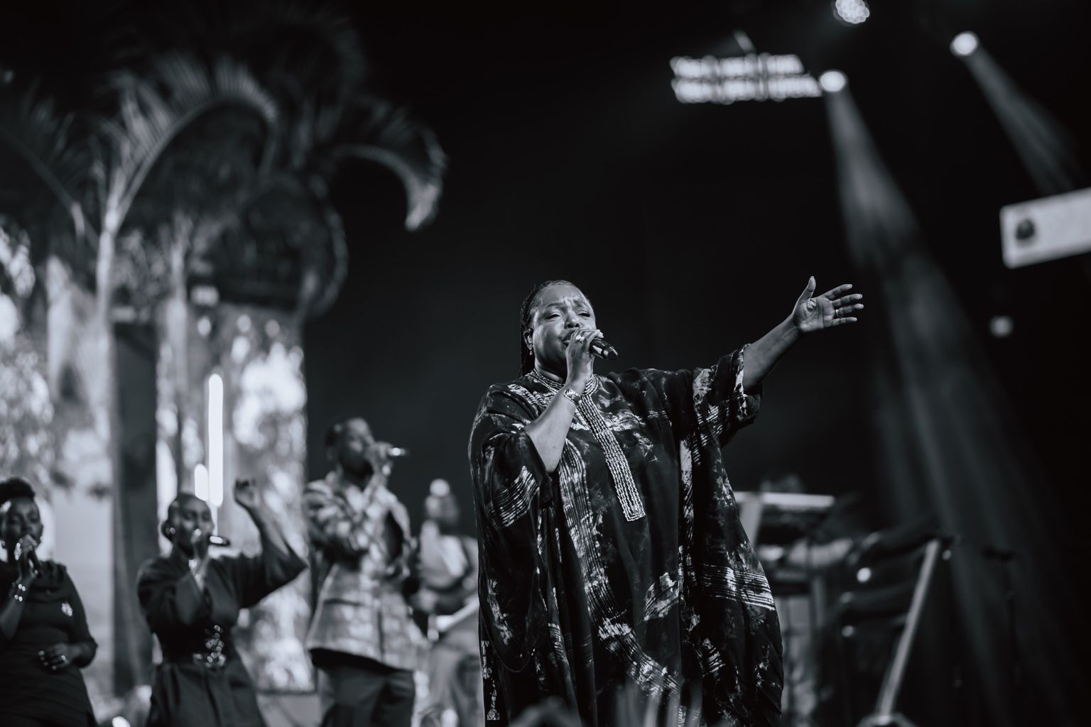 Black-and-white photograph of Chevelle Franklyn singing with her arm outstretched.