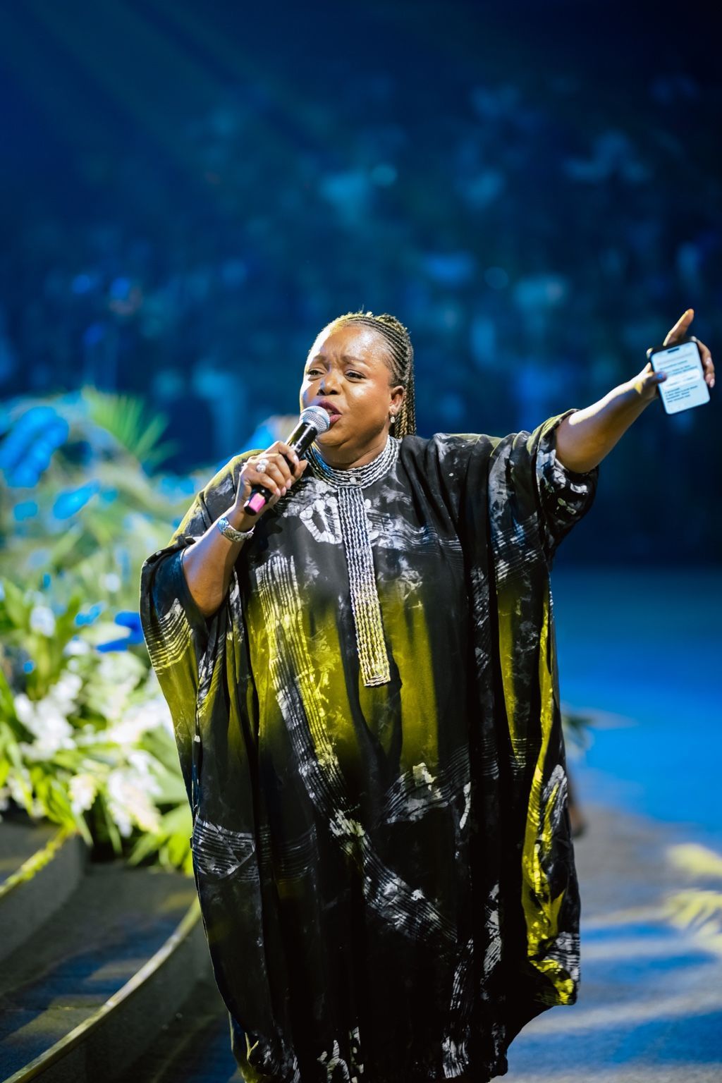 Chevelle Franklyn singing in a black dress with one arm extended at All Women Together 2026, Kigali.