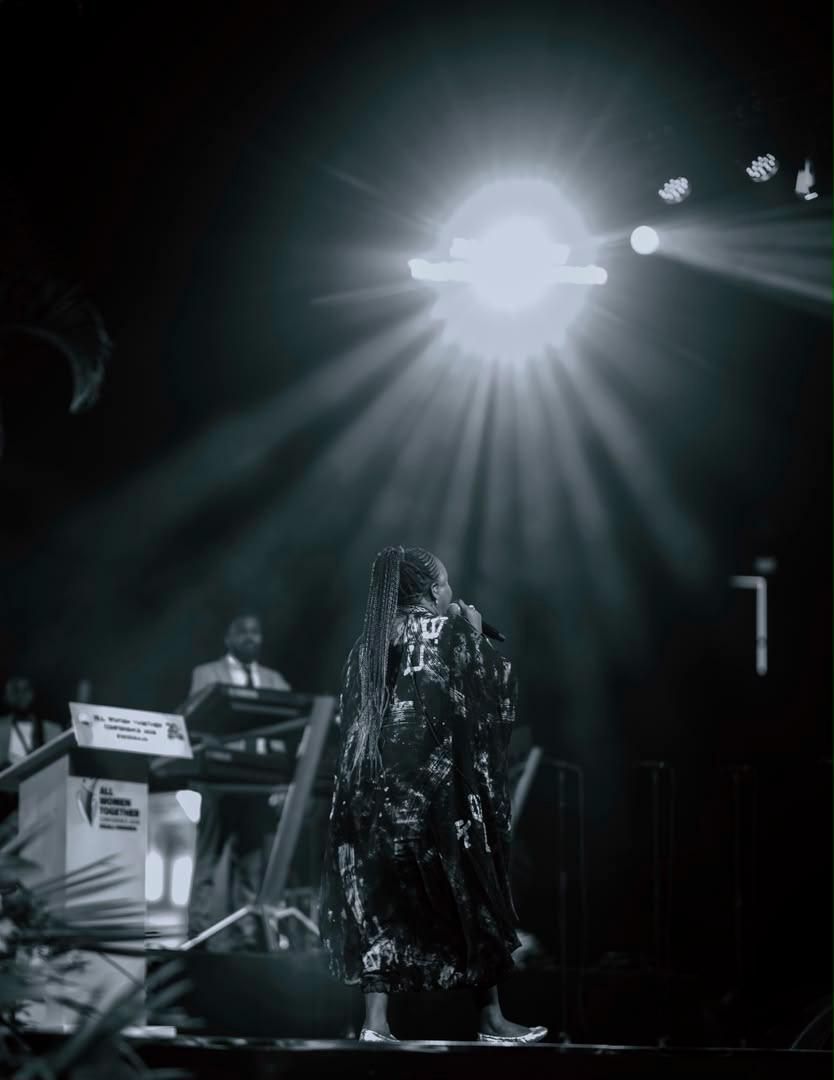 Black-and-white photograph of Chevelle Franklyn performing beneath a spotlight.