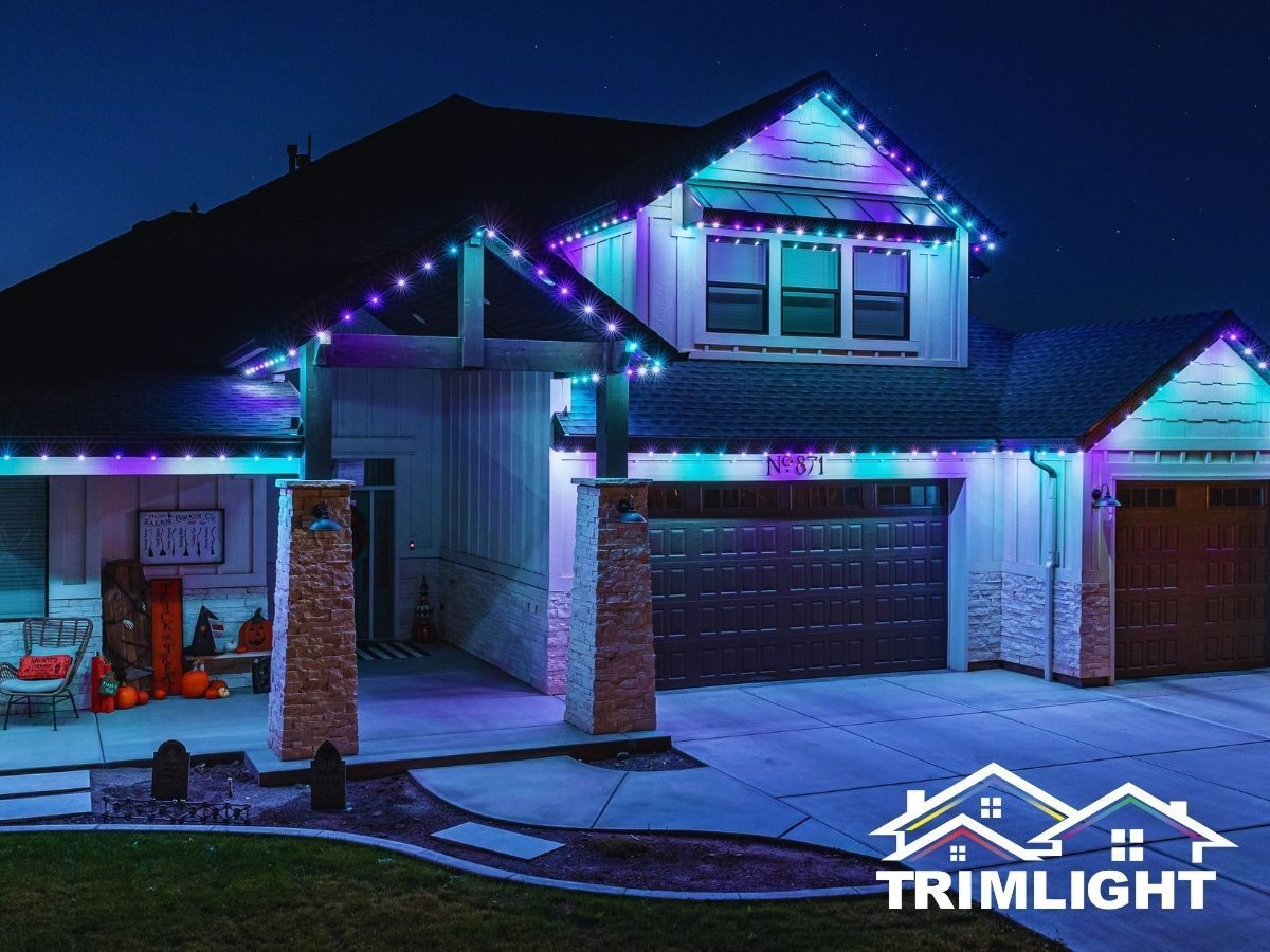 House exterior with colorful LED lights outlining the roof, columns, and garage at night.