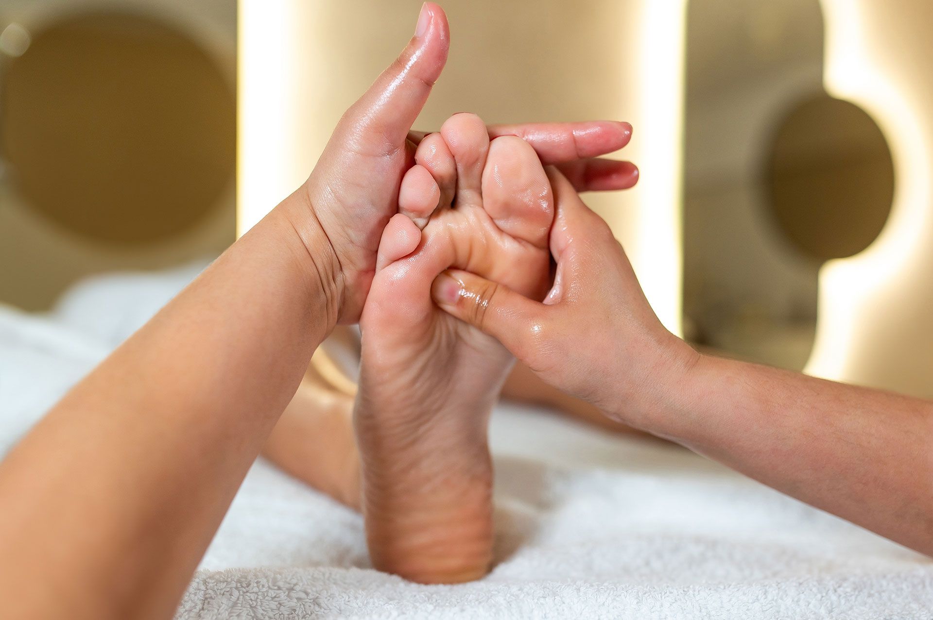 Hands holding cream shaped into a heart, with jar on fluffy white surface.