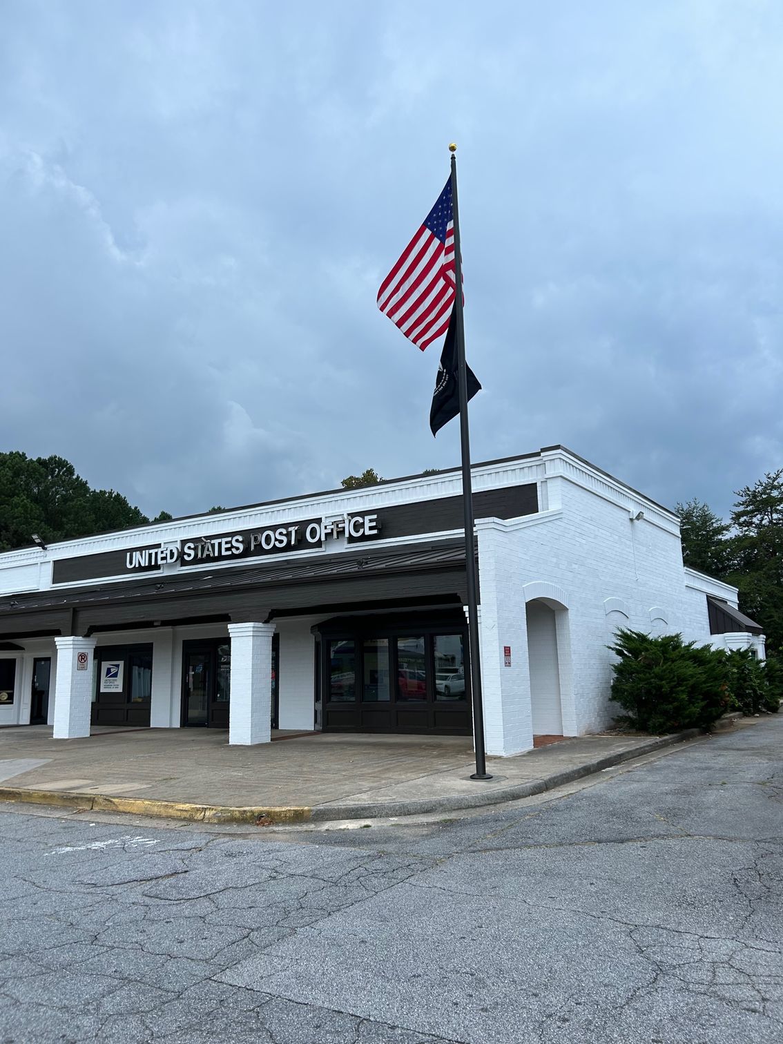 An american flag is flying in front of a white building.