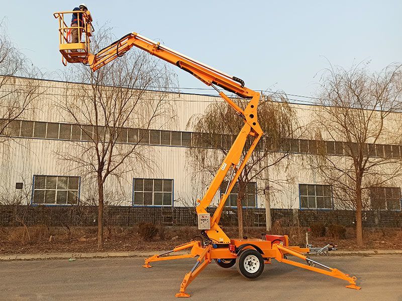 A man is standing in a bucket on a lift in front of a building.