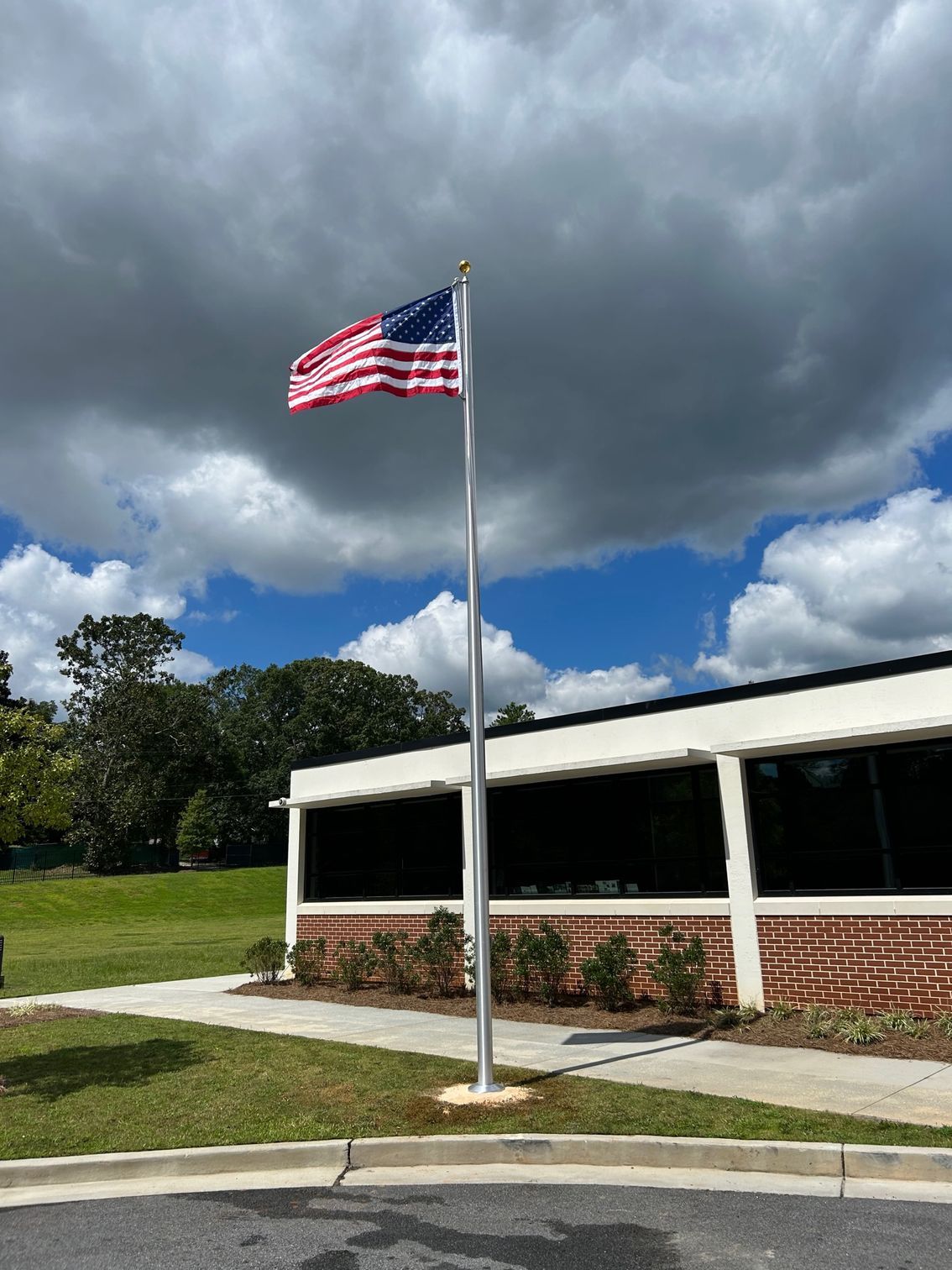 An american flag is flying on a pole in front of a building.