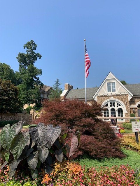 An american flag is flying in front of a house.