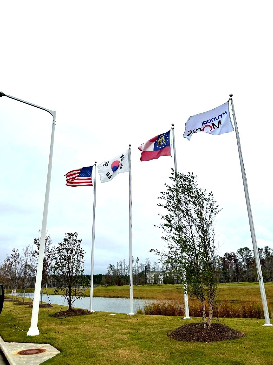 Four Flagpoles Displaying Various Flags